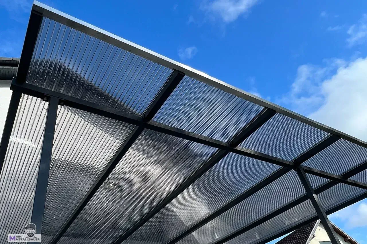 Terassenueberdachung aus Stahl mit verdunkelten Polycarbonatplatten